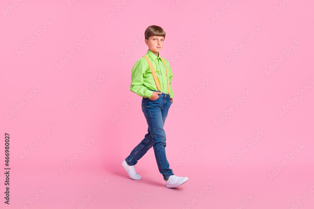 Full length body size view of attractive content boy walking isolated over bright pink color background