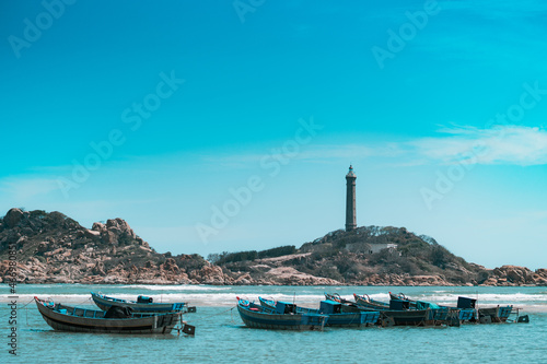Copy space sea nature landscape background. Nature reserve park, harbour bay, rocks coast, lighthouse on island mountain top. Sun day clear azure sky blue ocean. Fishing boats. Trip vacation travel