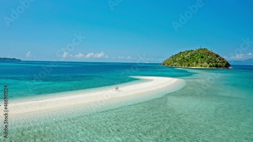 Happy couple walking on a perfect beach