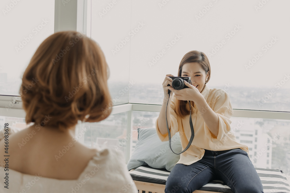 Asian woman photographer is taking a photo of her woman fashion model. Asian woman photographer is taking a photo of her woman fashion model.