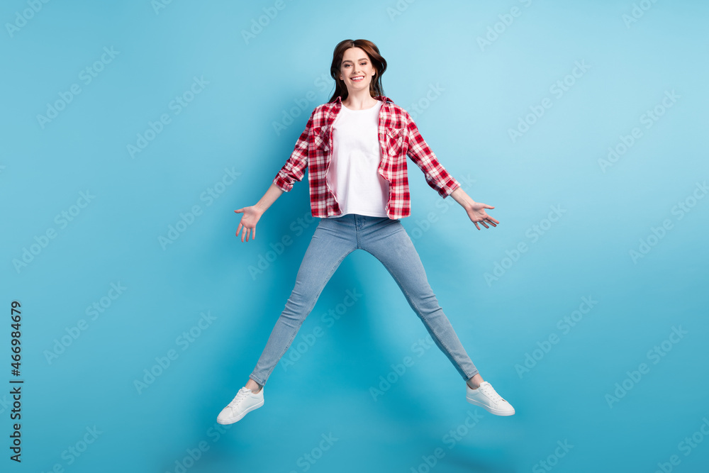 Full length photo of happy cheerful charming woman jump up good mood casual isolated on blue color background Full length photo of happy cheerful charming woman jump up good mood casual isolated on blue color background