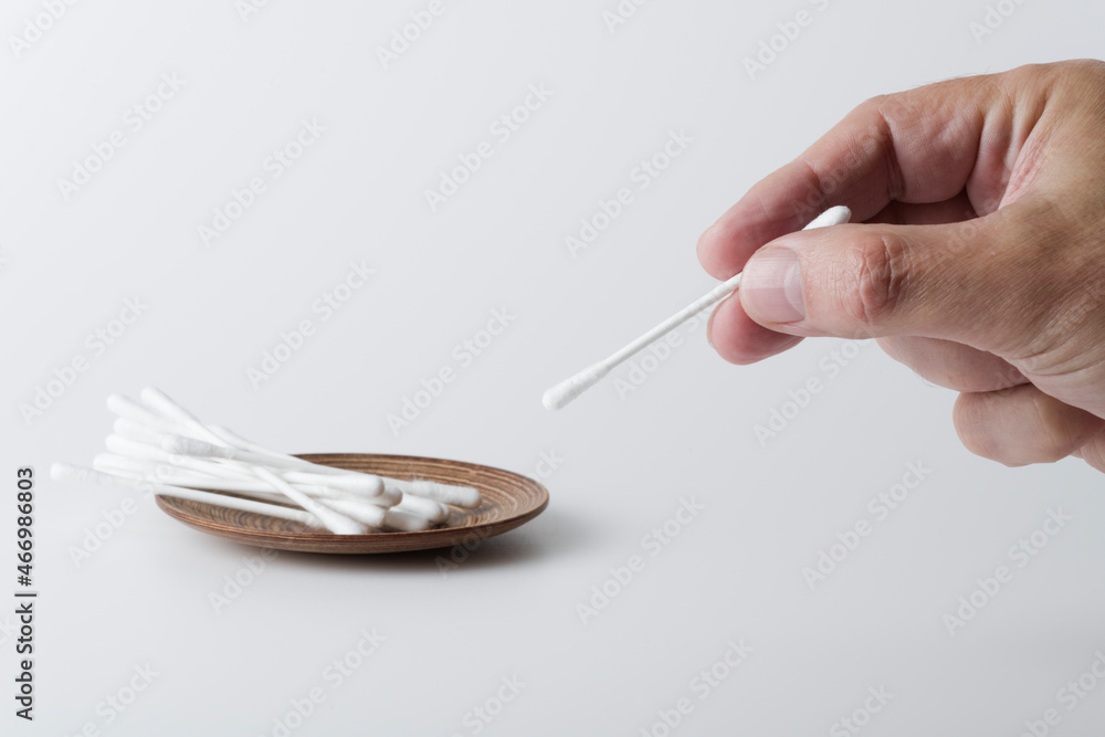 Hand mit Wattestäbchen (plastikfrei) Hand mit Wattestäbchen (plastikfrei)