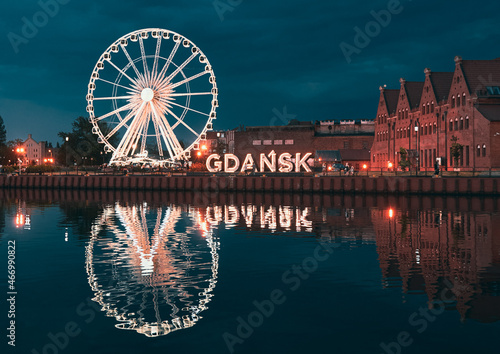 Reflection of the Ferris wheel in Gdansk, Poland. Old town center in the touristic city on the shore of the Baltic Sea in Poland. Beautiful night city lights photo