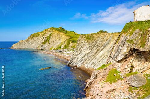 View of the cliff of Izurrun beach with its geological limestone rocks forming layers. Zumaya, Euskadi, Spain