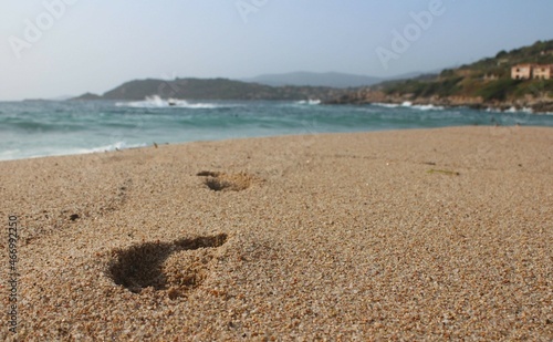 Fototapeta Naklejka Na Ścianę i Meble -  empreintes et traces de pieds dans le sable en bord de mer 