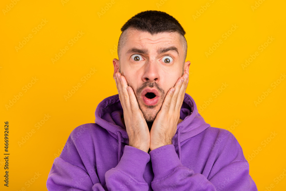 Photo of sad millennial brunet guy hands face wear purple hoodie isolated on yellow color background Photo of sad millennial brunet guy hands face wear purple hoodie isolated on yellow color background