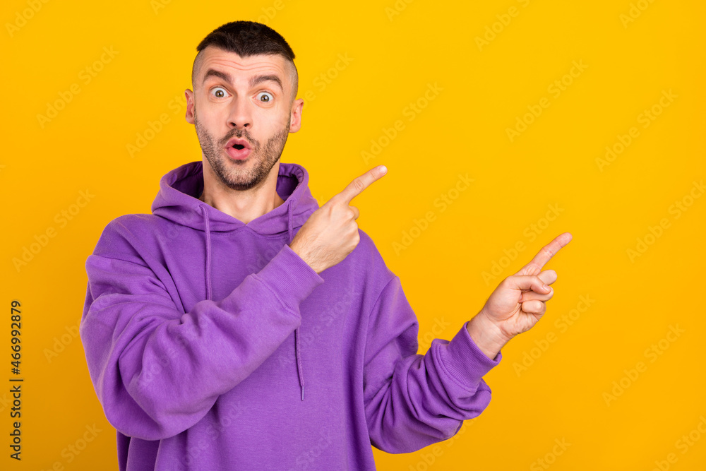 Portrait of attractive cheerful amazed guy demonstrating ad copy blank space isolated over bright yellow color background Portrait of attractive cheerful amazed guy demonstrating ad copy blank space isolated over bright yellow color background