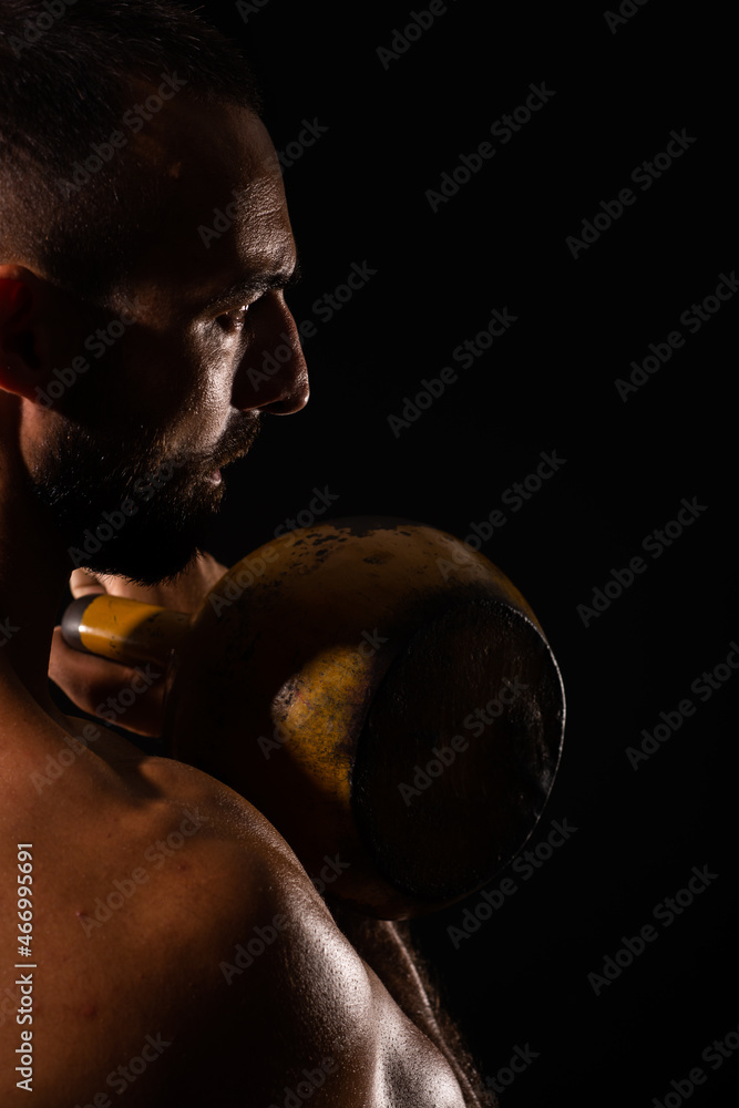 Fototapeta premium Portrait of handsome guy focusing on the dumbbell