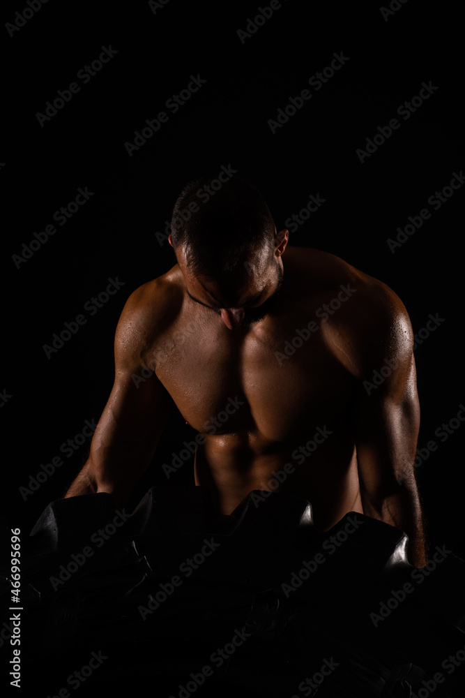 Lifting the tire while looking at his muscles Lifting the tire while looking at his muscles