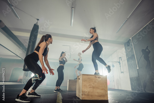 Fitness group of  strong women having cross-functional training in the gym