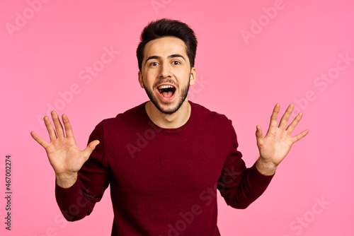 Cheerful bearded man in sweater posing pink background