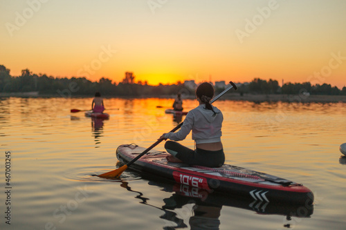 SUP a young girl paddle boarding at sunset © Oleh