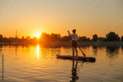 SUP a young girl paddle boarding at sunset