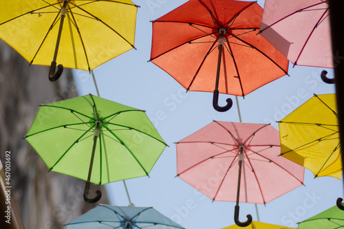 Close up of many colorful umbrellas hanged under the blue sky 