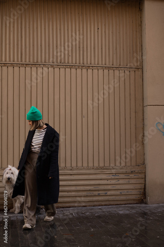 young woman walking with her dog old english sheepdog through the streets of the city