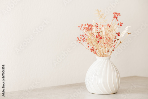 Fototapeta Naklejka Na Ścianę i Meble -  Modern dryed flowers bouquet in beige vase. Interior elegant home decor. Minimal floral arrangement. Copy space, front view