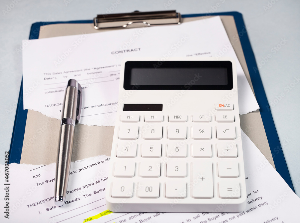 Torn contract and calculator for calculation losses. Terminated agreement concept. Torn contract and calculator for calculation losses. Terminated agreement concept.