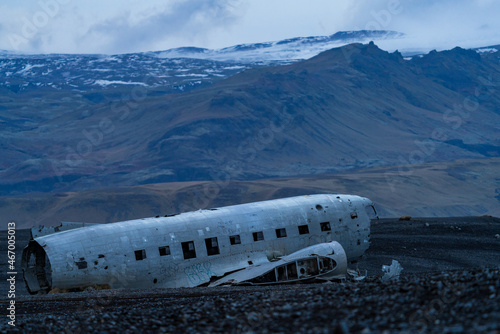 Wreck of an airplane against the mountains stranded in southern Iceland photo