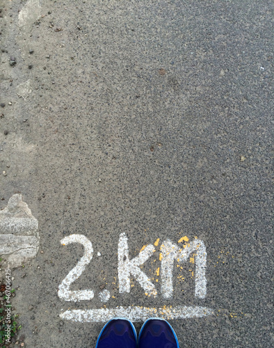 Overhead view of a runner standing by a 2km road marking, Malaysia photo