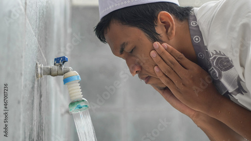 Close-up portrait of a man taking ablutions before prayer at a mosque