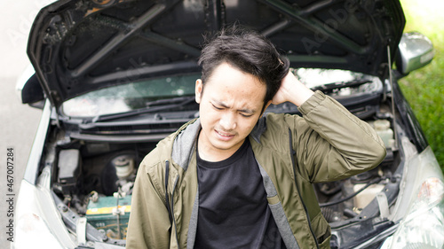 Portrait of a man standing by a broken down car photo