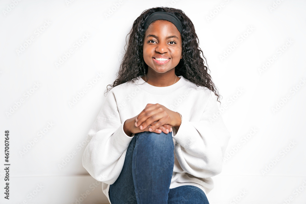 Young African Woman smiling and sit on White floor Young African Woman smiling and sit on White floor