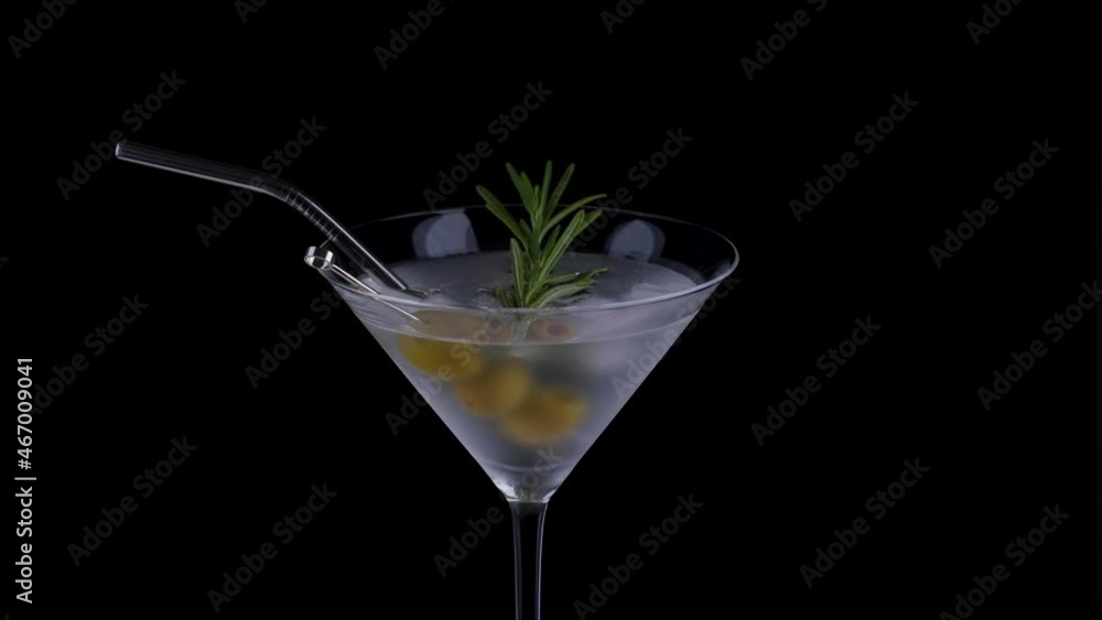 Alcohol cocktail with rosemary and green olives on a black background. Alcohol cocktail with rosemary and green olives on a black background.
