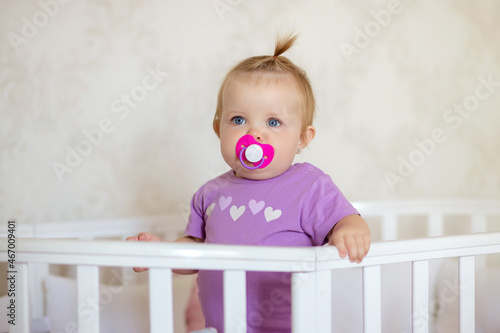 healthy baby playing and smiling in a crib