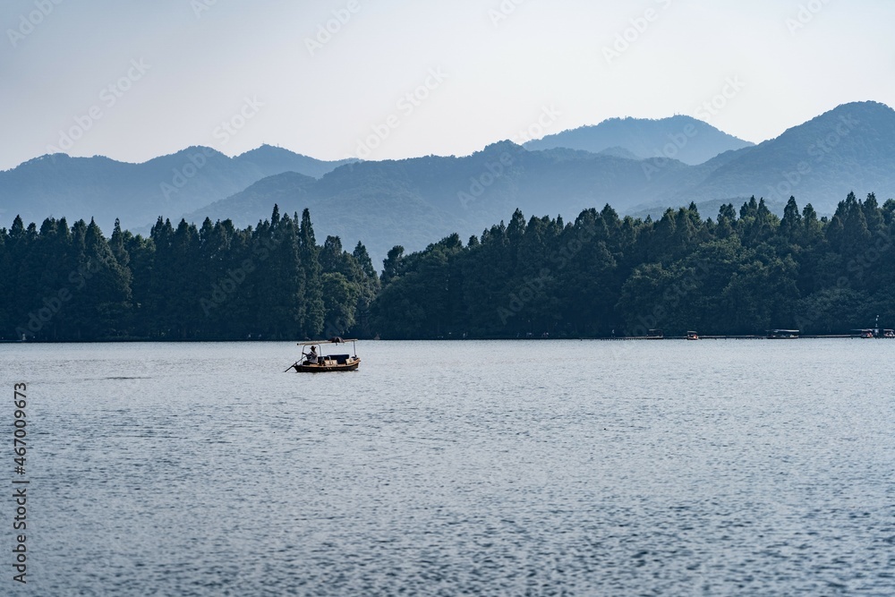 boat on west lake in Hangzhou with mountain background boat on west lake in Hangzhou with mountain background