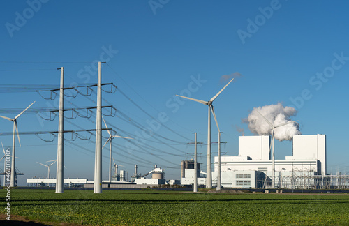 Fossil fuel (coal) power station, wind turbines and solar panels in the Eemshaven generating electricity. Energy transition concept.