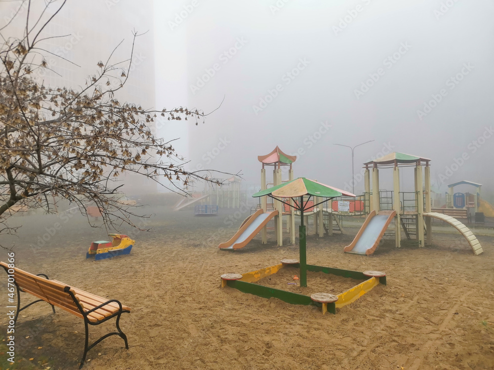 Fototapeta premium An empty playground on an autumn foggy day.