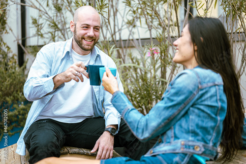 Dating online and meeting, young couple drinking coffee, enjoying flirt and conversation during weekend date, outdoor scene © MandriaPix