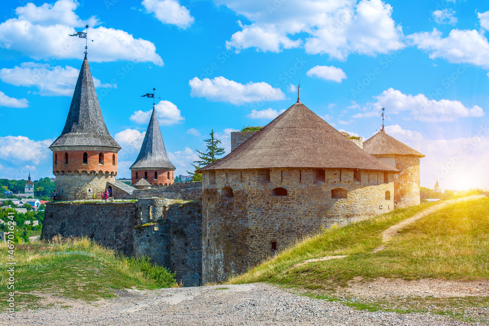 Photo of ancient stone castle with many hight towers in Kamyanets-Podilsky with sun