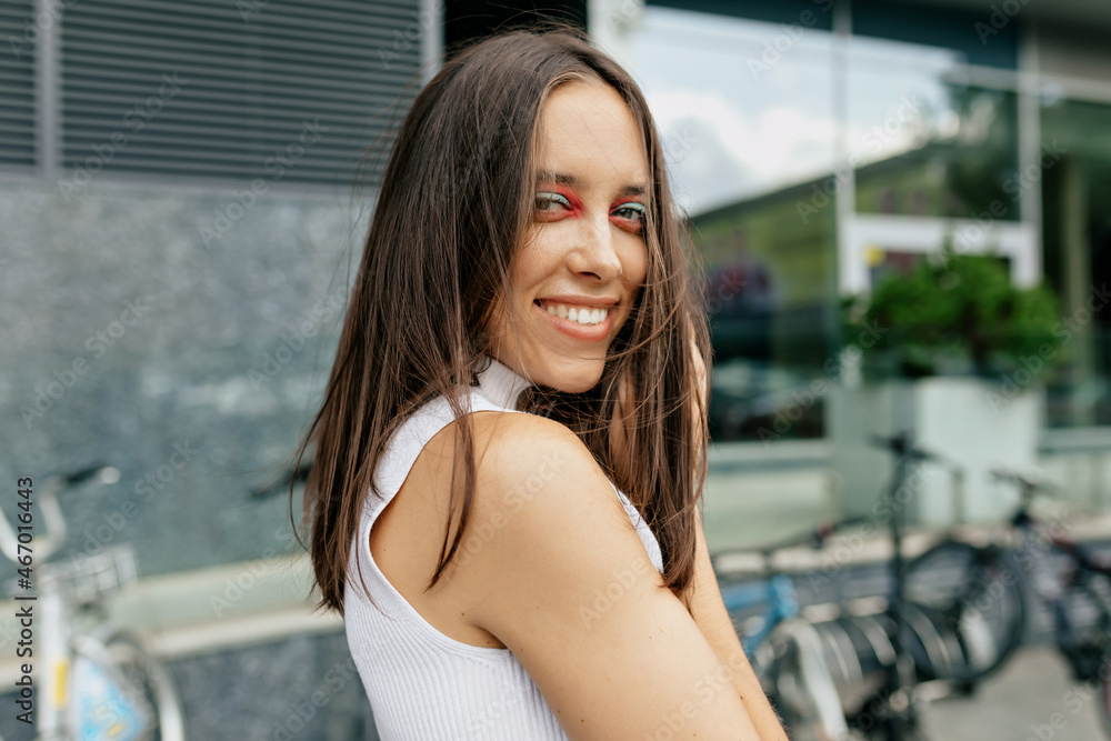 Close up outdoor portrait of attractive stylish woman with dark hair and bright holiday make up wearing white t-shirt Close up outdoor portrait of attractive stylish woman with dark hair and bright holiday make up wearing white t-shirt
