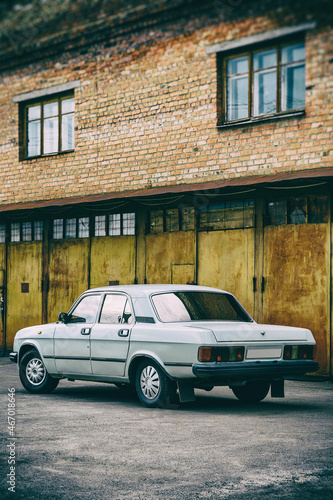 Photo of old car standing before rusty gate of building © Badunchik