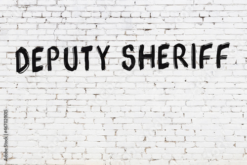 White wall with black paint inscription deputy sheriff on it photo