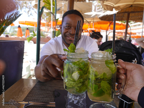 Black Couple Toasting with Mojito Cocktails at a Beach Restaurant in Monte Carlo, Monaco (Black Travelers on Vacation in Europe) - Cheers!