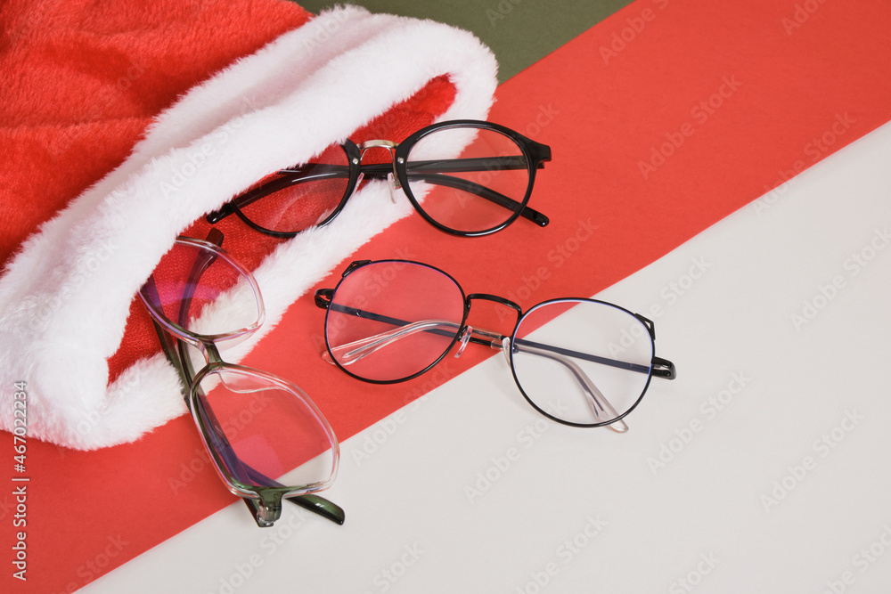 multiple eye glasses and santa hat on red and green background, optics  store sale before christmas Stock Photo | Adobe Stock