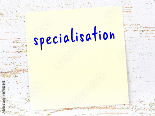 Yellow sticky note on wooden wall with handwritten word specialisation photo