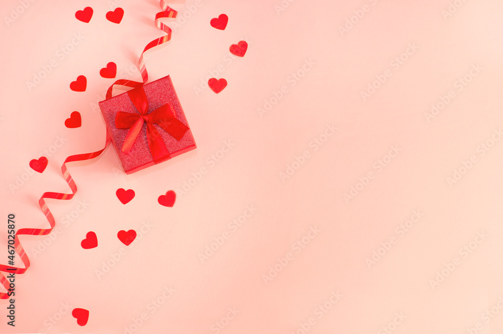 red box with a red bow on a rose background with hearts and a ribbon red box with a red bow on a rose background with hearts and a ribbon