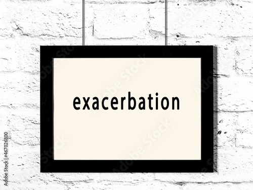 Photography Black frame hanging on white brick wall with inscription exacerbation