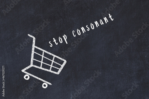 Chalk drawing of shopping cart and word stop consonant on black chalboard. Concept of globalization and mass consuming photo