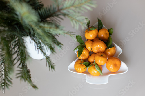 Wallpaper Mural Small ripe tangerines with leaves, on plate in shape of Christmas tree on beige background. Concept winter vitamin food. Moody still life festive composition. For greeting card, book, stories Torontodigital.ca
