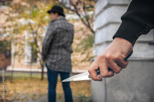A man holding a knife in his hand ready to attack a man. Crime is on the rise