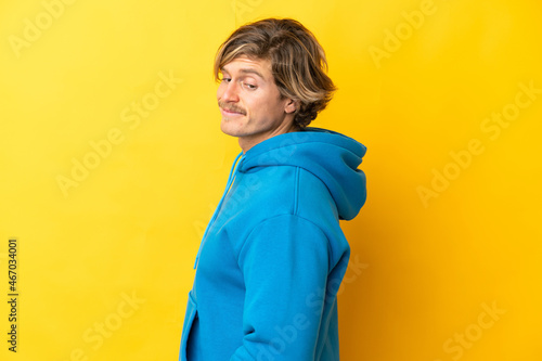Handsome blonde man isolated on yellow background . Portrait © luismolinero