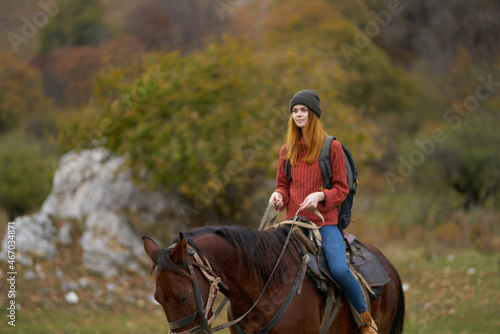 woman hiker riding a horse on nature travel
