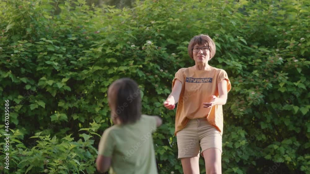 Mother and son play frisbee on grass lawn. Summer vibes. Outdoor leisure activity. Family life. Sports game at backyard. Mother and son play frisbee on grass lawn. Summer vibes. Outdoor leisure activity. Family life. Sports game at backyard.