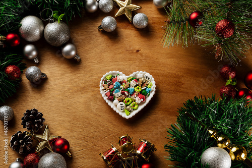 Φωτογραφία Christmas Sugar Comfit on a heart plate on a wood table,  top view, Christmas Ce