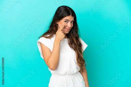 Young caucasian woman isolated on blue background showing something