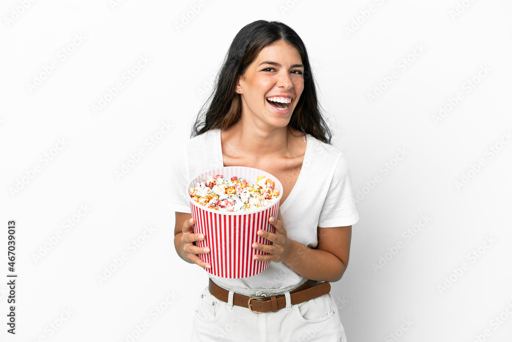 Young caucasian woman isolated on white background holding a big bucket of popcorns Young caucasian woman isolated on white background holding a big bucket of popcorns